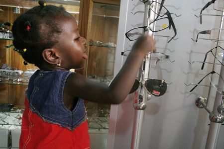 A young visitor checks out the inventory at Watborg Eye Services’ optical shop just outside of Accra, Ghana. Photo by Wairimu Gitahi.