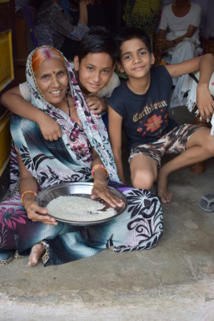 Premabai sits with her grandson as she sorts through a plate of rice grains
