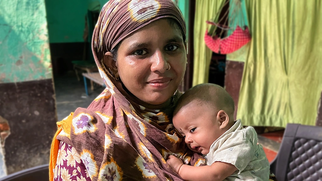 A mother holds a baby.