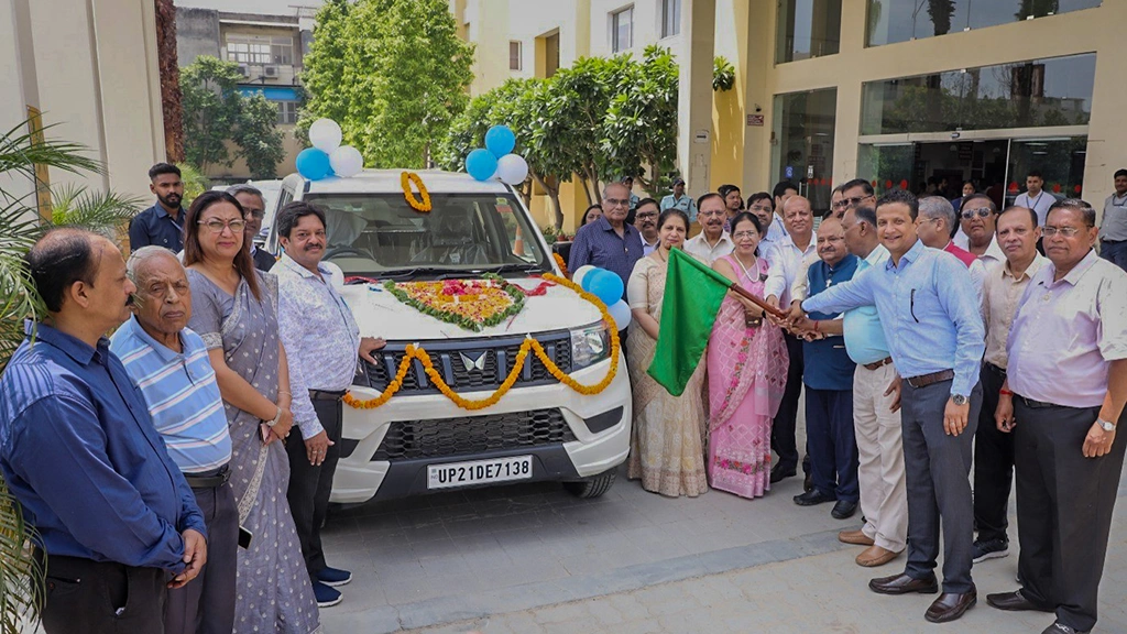 A group of people stand next to a van that is decorated with flower garlands.